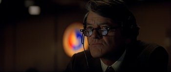 Movie still from “Capricorn One” (1977), directed by Peter Hyams – An older man wearing glasses and a suit; Close Up shot, Low angle