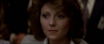 Movie still from “Capricorn One” (1977), directed by Peter Hyams – A woman's face in a dark room; Close Up shot, Over the shoulder angle