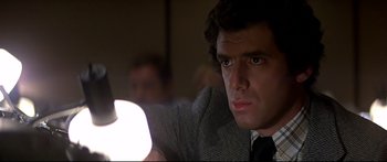 Movie still from “Capricorn One” (1977), directed by Peter Hyams – A man in a suit and tie holding a light; Close Up shot, Low angle