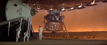 Movie still from “Capricorn One” (1977), directed by Peter Hyams – A man standing in front of an old moon lander; Extreme Wide shot, High angle