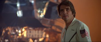 Movie still from “Capricorn One” (1977), directed by Peter Hyams – A man standing in front of a building at night; Close Up shot, Low angle