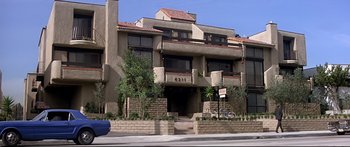 Movie still from “Capricorn One” (1977), directed by Peter Hyams – A building that has a bike parked on the side of it; Extreme Wide shot, Low angle