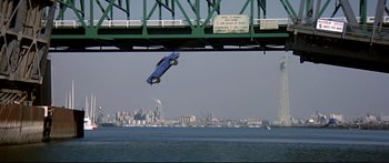 Movie still from “Capricorn One” (1977), directed by Peter Hyams – A blue car flying through the air over a body of water; Wide shot, High angle
