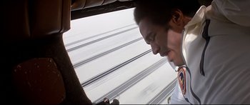 Movie still from “Capricorn One” (1977), directed by Peter Hyams – A man looking out the window of an airplane; Close Up shot, Overhead angle