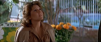 Movie still from “Capricorn One” (1977), directed by Peter Hyams – A person wearing a jacket near flowers; Close Up shot, Low angle