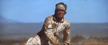 Movie still from “Capricorn One” (1977), directed by Peter Hyams – A man in a white jacket and a headband; Medium shot, Low angle