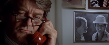 Movie still from “Capricorn One” (1977), directed by Peter Hyams – A man with glasses is talking on the phone; Close Up shot, Over the shoulder angle