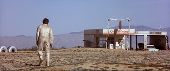 Movie still from “Capricorn One” (1977), directed by Peter Hyams – A man standing in the middle of an empty field; Extreme Wide shot, Low angle