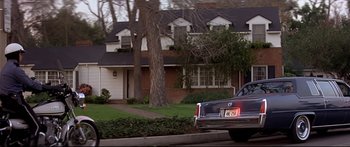 Movie still from “Capricorn One” (1977), directed by Peter Hyams – A car is parked in front of a house; Wide shot, Low angle