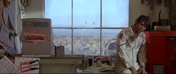 Movie still from “Capricorn One” (1977), directed by Peter Hyams – A window view of a mountain range and a field; Medium shot, Low angle