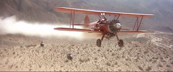 Movie still from “Capricorn One” (1977), directed by Peter Hyams – An airplane is flying low over the desert; Wide shot, Low angle