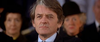 Movie still from “Capricorn One” (1977), directed by Peter Hyams – A person wearing a suit and tie; Close Up shot, Low angle