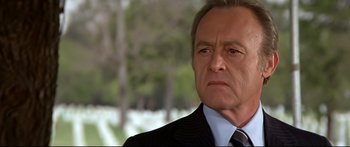 Movie still from “Capricorn One” (1977), directed by Peter Hyams – A man in a suit and tie looking at the camera; Close Up shot, Low angle