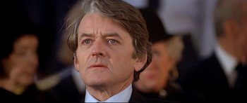 Movie still from “Capricorn One” (1977), directed by Peter Hyams – A person wearing a suit and tie; Close Up shot, Low angle