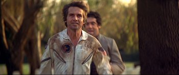 Movie still from “Capricorn One” (1977), directed by Peter Hyams – A man in a white jacket and a man in a brown jacket; Medium shot, Low angle