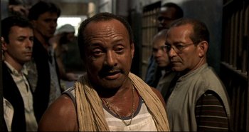 Movie still from “Carandiru” (2003), directed by Hector Babenco – A group of men standing next to each other in a building; Close Up shot, Over the shoulder angle
