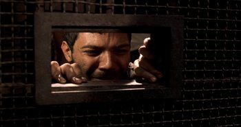 Movie still from “Carandiru” (2003), directed by Hector Babenco – A man looking through a window in a jail cell; Close Up shot, High angle
