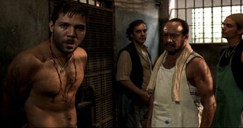 Movie still from “Carandiru” (2003), directed by Hector Babenco – A group of men standing next to each other in a room; Medium shot, Over the shoulder angle