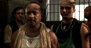 Movie still from “Carandiru” (2003), directed by Hector Babenco – A group of men standing next to each other in a room; Close Up shot, Low angle