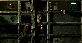 Movie still from “Carandiru” (2003), directed by Hector Babenco – A group of people looking through a window; Close Up shot, Low angle