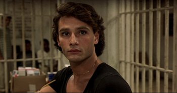 Movie still from “Carandiru” (2003), directed by Hector Babenco – A man with long brown hair wearing a black t - shirt; Close Up shot, High angle