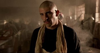 Movie still from “Carandiru” (2003), directed by Hector Babenco – A man with a bald head and a scarf around his neck; Close Up shot, Low angle
