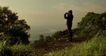 Movie still from “Carandiru” (2003), directed by Hector Babenco – A man standing on top of a hill looking through binoculars; Extreme Wide shot, Low angle
