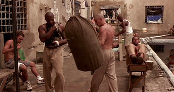 Movie still from “Carandiru” (2003), directed by Hector Babenco – A group of men practicing boxing in an urban setting; Wide shot, High angle