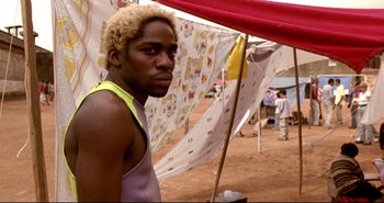 Movie still from “Carandiru” (2003), directed by Hector Babenco – A man standing in front of a bunch of clothes; Close Up shot, Low angle