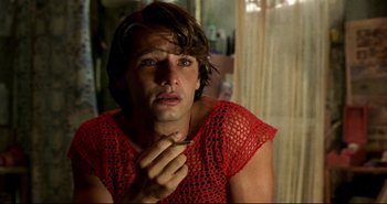 Movie still from “Carandiru” (2003), directed by Hector Babenco – A man in a red shirt is holding a cigarette; Close Up shot, Over the shoulder angle