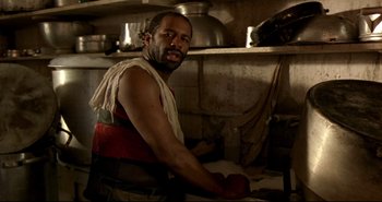 Movie still from “Carandiru” (2003), directed by Hector Babenco – A man wearing an apron in a kitchen; Close Up shot, Low angle