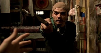 Movie still from “Carandiru” (2003), directed by Hector Babenco – A man holding a knife in his right hand; Close Up shot, High angle