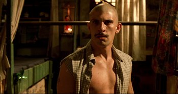 Movie still from “Carandiru” (2003), directed by Hector Babenco – A man with no shirt and no shirt is looking at the camera; Close Up shot, Low angle