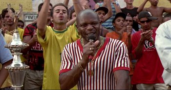 Movie still from “Carandiru” (2003), directed by Hector Babenco – A group of people standing in front of a microphone; Medium shot, Low angle