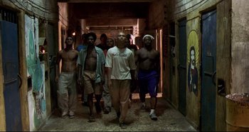 Movie still from “Carandiru” (2003), directed by Hector Babenco – A group of young men walking down a hallway; Wide shot, Low angle
