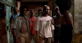Movie still from “Carandiru” (2003), directed by Hector Babenco – A group of men standing next to each other in a room; Medium shot, Low angle