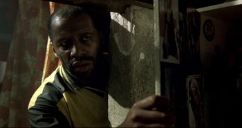 Movie still from “Carandiru” (2003), directed by Hector Babenco – A man holding a knife in his hand and looking at the camera; Close Up shot, Low angle