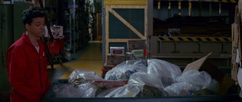 Movie still from “Career Opportunities” (1991), directed by Bryan Gordon – Many bags of food in this warehouse; Medium shot, Over the shoulder angle