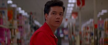 A man in a red shirt is looking at the camera