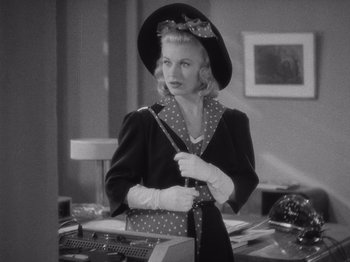 Movie still from “Carefree” (1938), directed by Mark Sandrich – A black and white photo of a woman in a hat; Medium shot, Over the shoulder angle