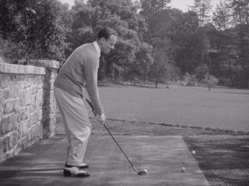 Movie still from “Carefree” (1938), directed by Mark Sandrich – A black and white photo of a man holding a golf club; Medium shot, High angle