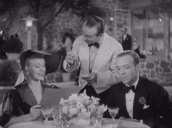 Movie still from “Carefree” (1938), directed by Mark Sandrich – An old black and white photo of two men and a woman; Medium shot, Over the shoulder angle