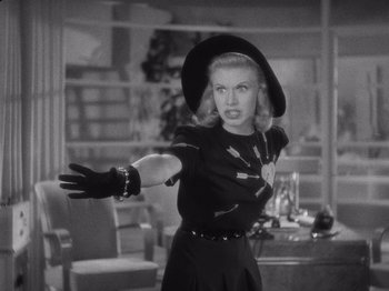 Movie still from “Carefree” (1938), directed by Mark Sandrich – A black and white photo of a woman in a hat and gloves; Medium shot, Low angle