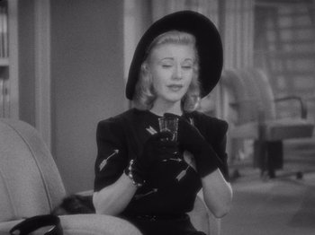 Movie still from “Carefree” (1938), directed by Mark Sandrich – A black and white photo of a woman wearing a hat and gloves; Close Up shot, High angle