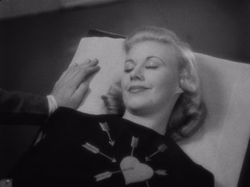 Movie still from “Carefree” (1938), directed by Mark Sandrich – An old photo of a woman laying on a bed; Close Up shot, Overhead angle