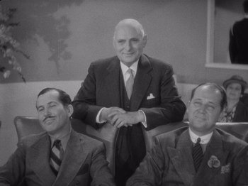 Movie still from “Carefree” (1938), directed by Mark Sandrich – A black - and - white photo of a man in a suit and tie; Medium shot, High angle