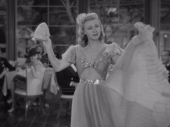 Movie still from “Carefree” (1938), directed by Mark Sandrich – A woman in a long dress holding a fan; Medium shot, Low angle