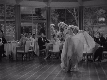 Movie still from “Carefree” (1938), directed by Mark Sandrich – A man and a woman dancing in front of a group of people; Wide shot, Low angle