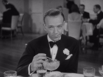 Movie still from “Carefree” (1938), directed by Mark Sandrich – An old photo of a man sitting at a dinner table; Close Up shot, High angle