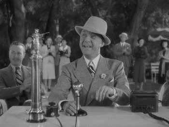 Movie still from “Carefree” (1938), directed by Mark Sandrich – An old photo of a man sitting at a table; Medium shot, Low angle